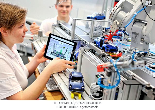 The porsche apprentices Sarah Luethen and Lucas Mauersberger work on a model of a glass glueing plant at the new vocational traning centre in Leipzig, Germany
