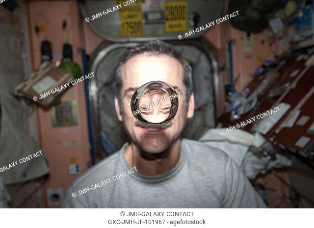 Canadian Space Agency astronaut Chris Hadfield, Expedition 34 flight engineer, watches a water bubble float freely between him and the camera