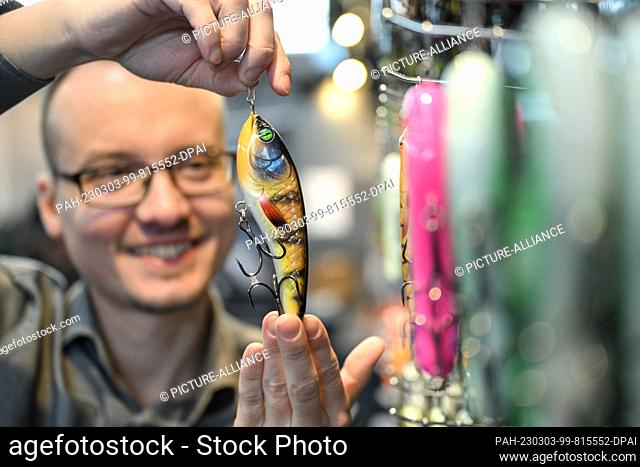 03 March 2023, Baden-Württemberg, Friedrichshafen Am Bodensee: Employee Ric from lure manufacturer Forge & Lures shows a lure for fishing