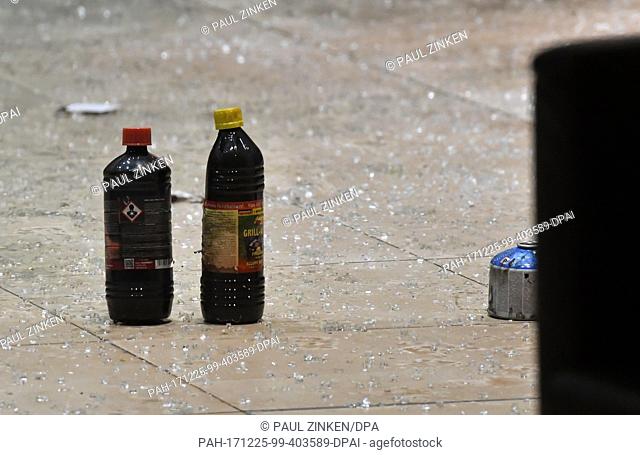 Two bottles of barbecue lighter fluid and a gas cartridge on the ground, which is covered with shards, at SPD party headquarters in Berlin, Germany