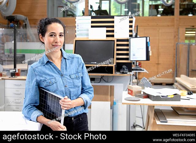 Businesswoman with solar panel model in factory