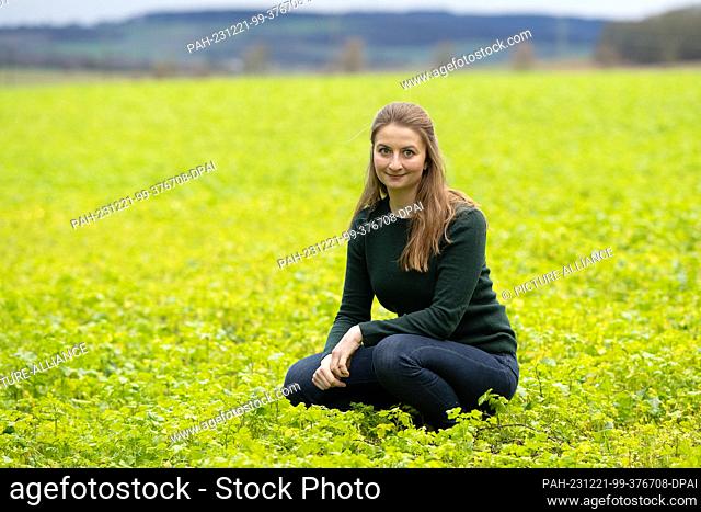 21 December 2023, Lower Saxony, Göttingen: Marie von Schnehen, a farmer, sits on a field with a catch crop at the traditional farm Hofgut Klein-Schneen near...