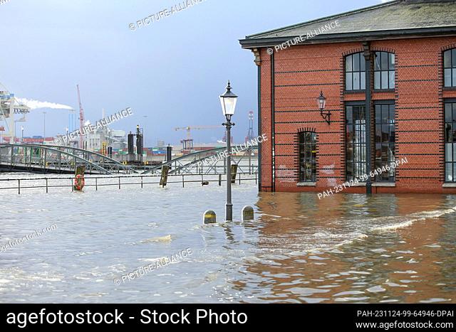 24 November 2023, Hamburg: The water of the Elbe is pushed onto the Hamburg fish market during a storm surge. According to the Federal Maritime and Hydrographic...