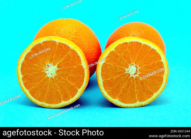 Oranges fruits full and sectioned on blue background. Healthy eating organic food items