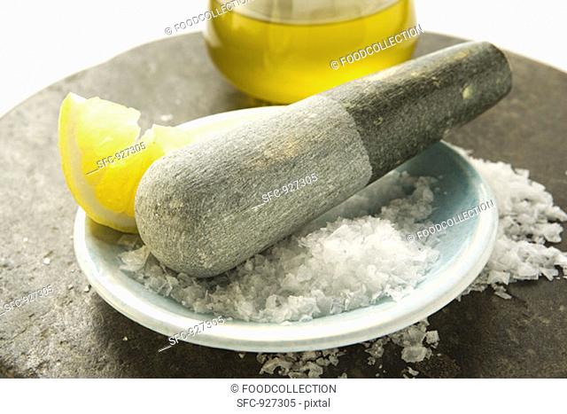 Coarse salt with pestle, lemon and olive oil