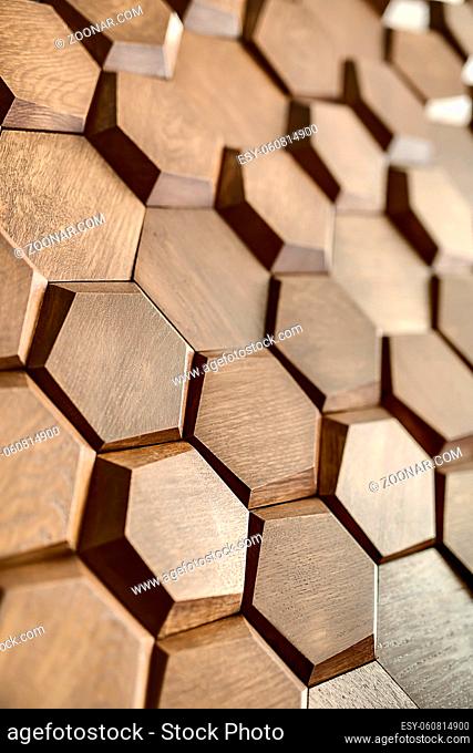 Elegant wooden wall textured with a lot of the hexagons. Closeup. Indoors. Vertical