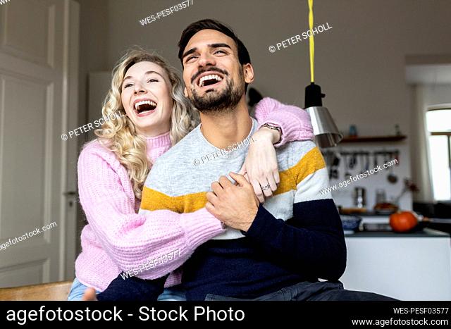 Young couple laughing together at home
