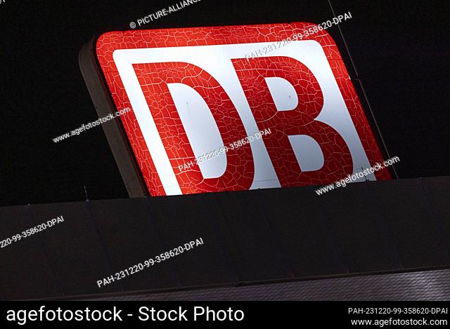 20 December 2023, North Rhine-Westphalia, Cologne: An illuminated Deutsche Bahn logo can be seen on the roof of the main station