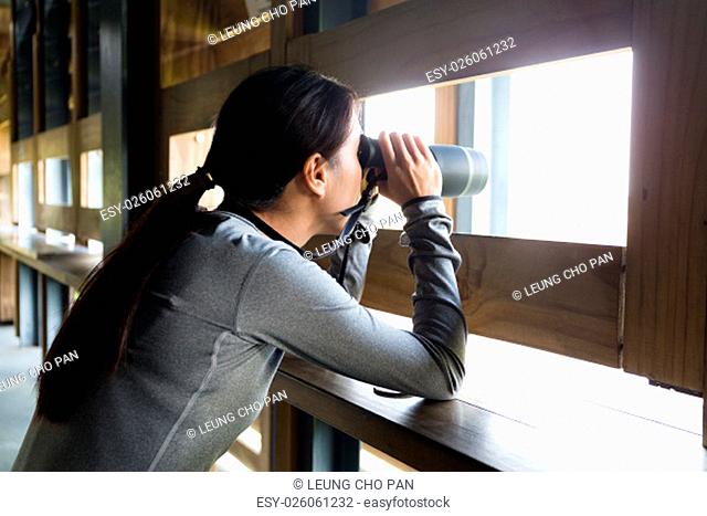 Asian Young woman looking though binoculars for birdwatching