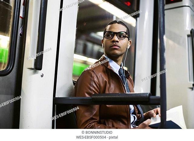 Businessman with book on the subway train