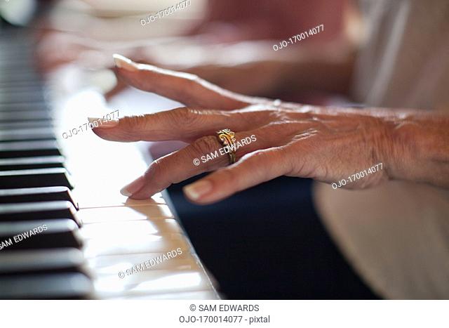 Close up of girl’s hands on piano