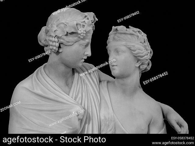 Ancient sculpture of Bacchus and Ariadne. Marble man and woman statue isolated on black background. Ariadne was the daughter of Minos King of Crete