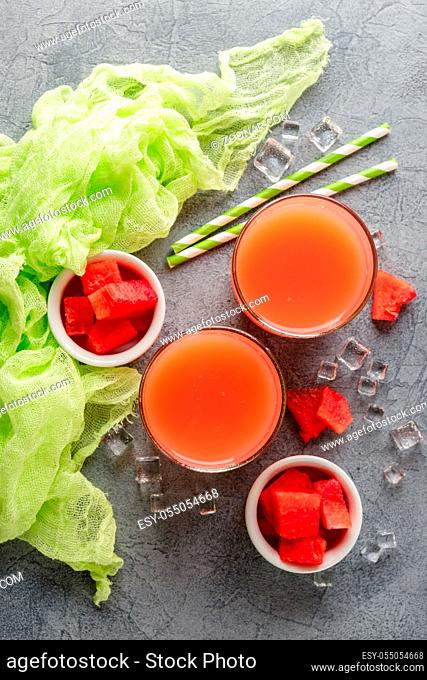 Watermelon drink with ice in glasses on gray concrete background. Top view