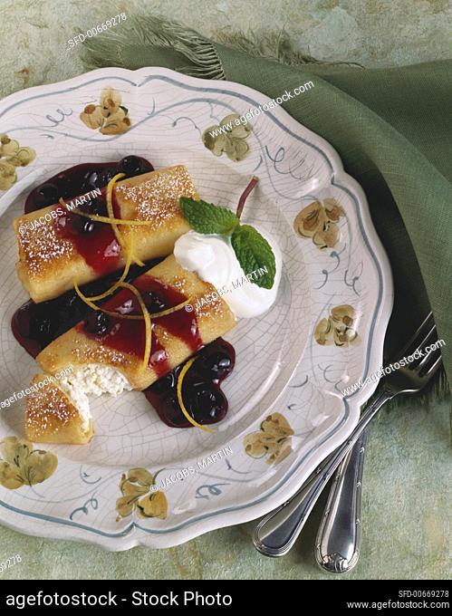 Serving of Cheese Blintzes Topped with Blueberry Sauce