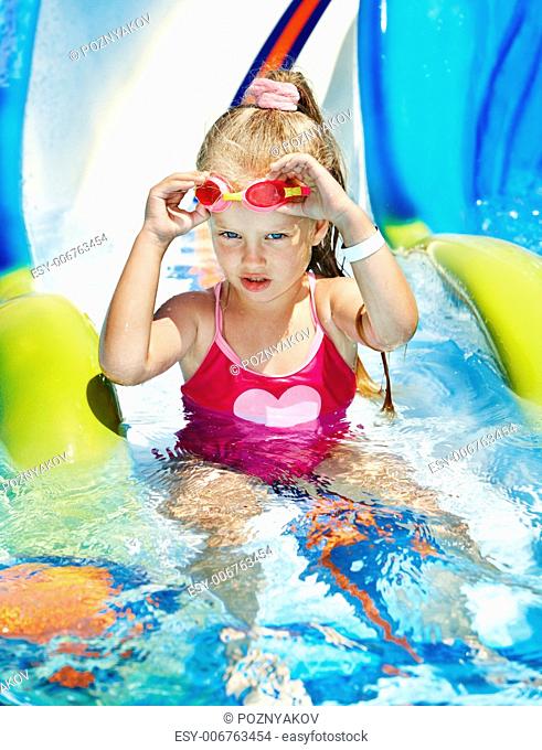 Child on water slide at aquapark. Summer holiday