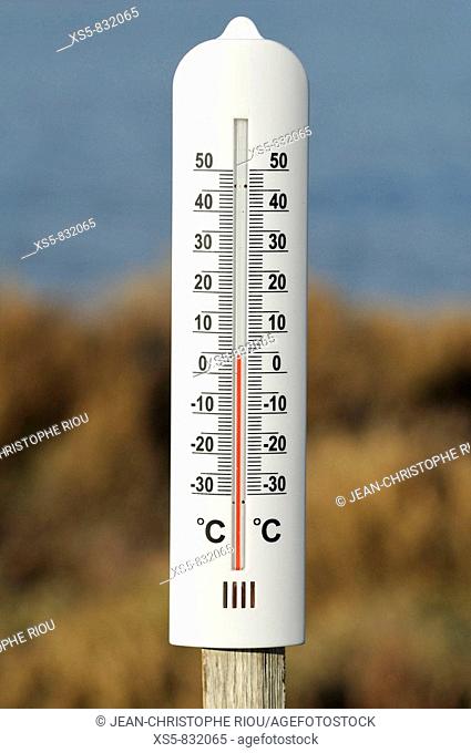 Closeup Of An Outdoor Thermometer Hanging On A Concrete Wall Stock