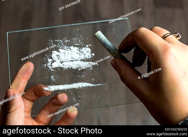 cocaine or speed in a line. addict with euro bill for snorting, drug abuse concept close-up crack, heroin