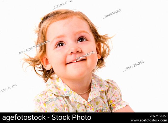 Cheerful two years girl staring up dreaming isolated on white