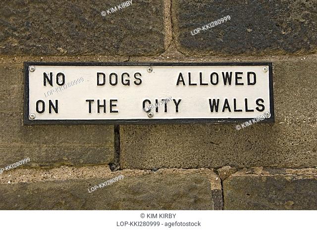 England, North Yorkshire, York, 'NO DOGS ALLOWED ON THE CITY WALLS' sign, mounted on the historic city walls in York