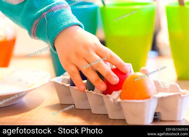 Mother and child painting eggs for Easter holidays