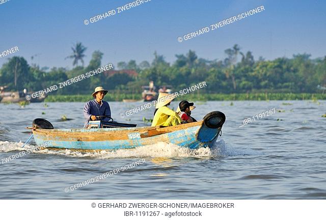 Fishing boat with woman, man and child on the Mekong River, Vinh Long, Mekong Delta, Vietnam, Asia