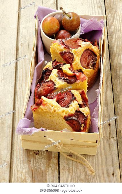 Three slices of plum cake in a wooden basket