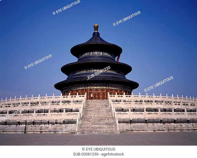 Temple of Heaven. Hall of Prayer for Good Harvests with western tourist standing at top of steps to entrance