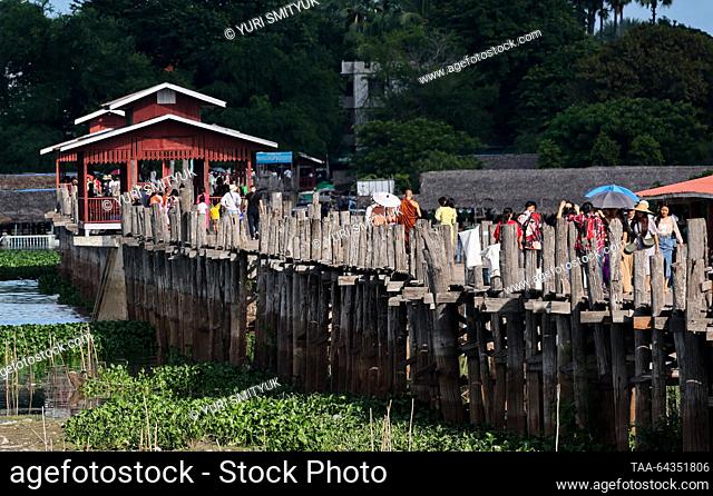 MYANMAR, MANDALAY - OCTOBER 25, 2023: Tourists are seen on the U Bein Bridge spanning Lake Taungthaman. The 1.2-kilometre bridge is believed to be the world's...