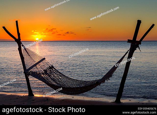 Hängematte am Strand vor dem Sonnenuntergang in Le Morne, Mauritius, Afrika. Hammock on the beach in front of the sunset in Le Morne, Mauritius, Africa