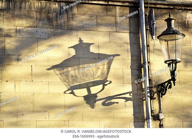 Lamppost against a mergel wall and its shadow cast on the wall  Mergel is a stone used in many of the older buildings in Maastricht  Photo taken in the...