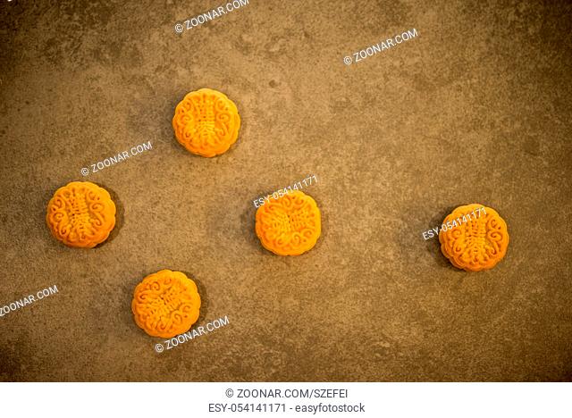 Traditional baked mooncakes is offered to friends or family during Mid-Autumn Festival. Flatlay table top view on dark background