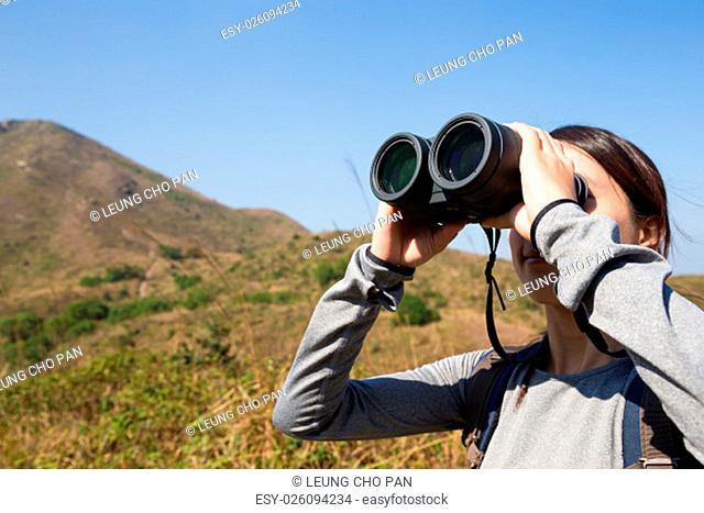 Young Woman watching though binocular