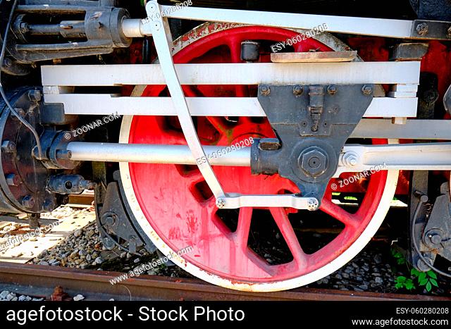 Vintage steam locomotive detail with cranks and red wheels, green bodywork, industrial heritage and transportation