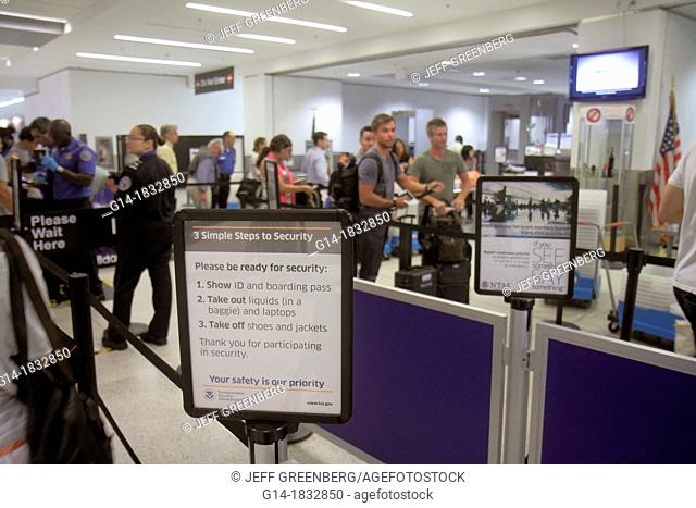 Florida, Miami, Miami International Airport, MIA, security check, checkpoint, TSA, Transportation Security Administration, passengers, man, woman, sign