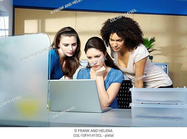 Group of young women with laptop at desk