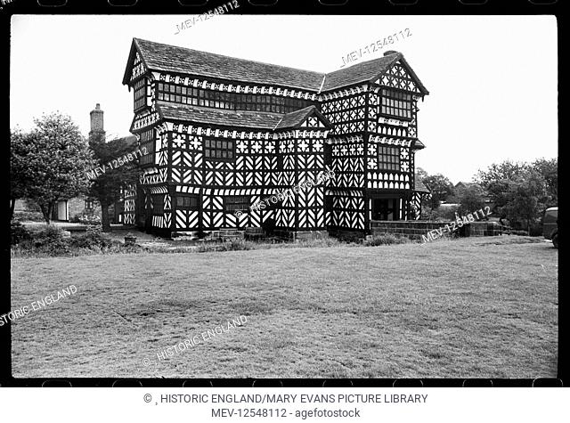 Exterior view of Little Moreton Hall taken from the south-west. At the far right side is the three-storeyed gabled porch that reaches the single-span ashlar...