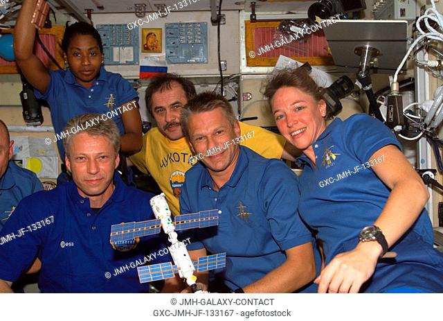 Crewmembers onboard the International Space Station pose for a photo in the Zvezda Service Module while Space Shuttle Discovery was docked with the station