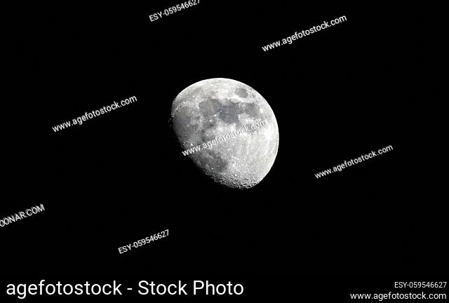 Horizontal view of a three quarter moon in great detail in a black night sky