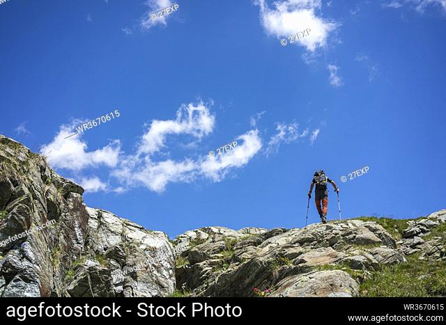 Man hiking on top of mountain at Western Rhaetian Alps, Sondrio, Italy
