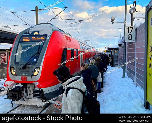 05 December 2023, Bavaria, Dachau: Numerous train passengers wait in Dachau for one of the few trains heading towards Munich in the current weather conditions
