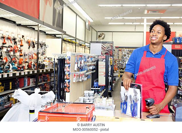 African American male store clerk at checkout counter in super market