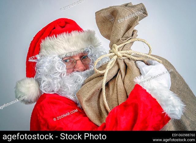 Santa Claus holding big sack full of christmas presents