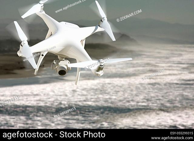 Unmanned Aircraft System (UAV) Quadcopter Drone In The Air Over The Ocean Coastline