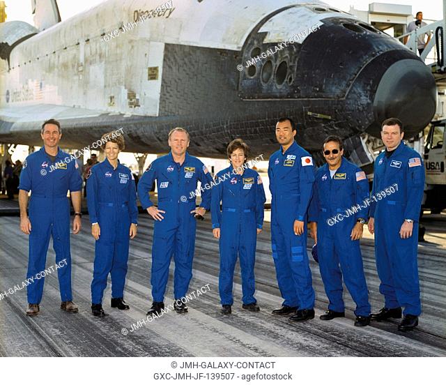 The STS-114 crewmembers gather for a crew photo in front of the Space Shuttle Discovery following landing at Edwards Air Force Base in California