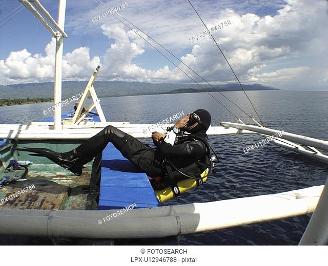 Diver making a back roll of a local dive boat called a Banca. Moalboal. Philippines