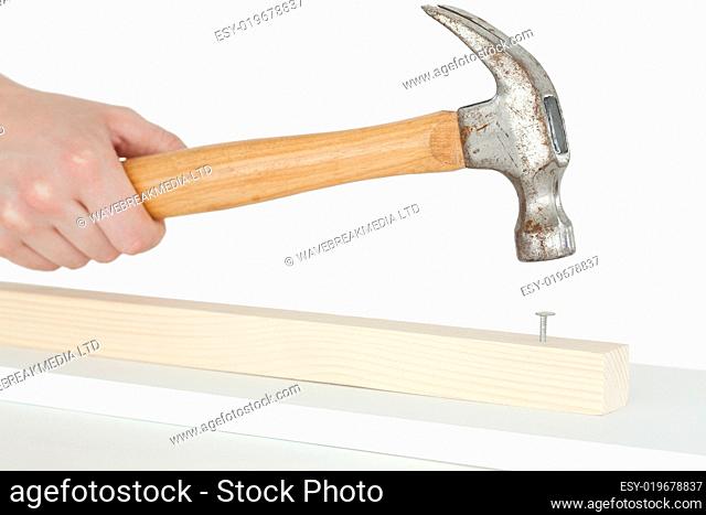 Hammer driving a nail into a wooden board