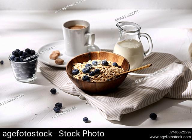 oatmeal with blueberries, milk and cup of coffee