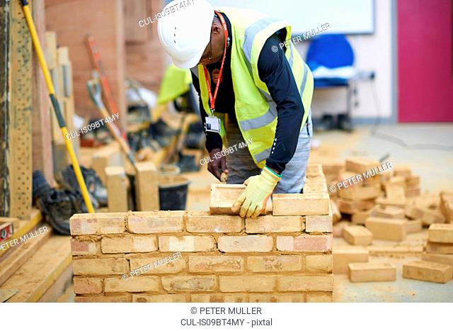 Lecturer building brick wall in classroom