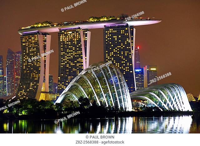 Night scene of the city skyline of Singapore showing the Flower Dome and Cloud Forest domes in the Gardens by the Bay and the Marina Bay Sands Hotel