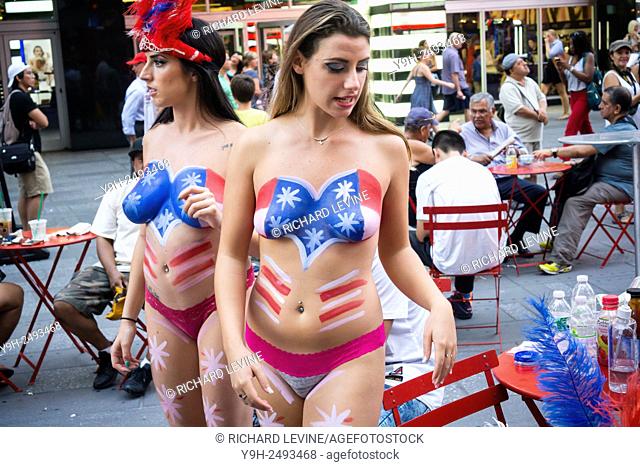 Body painted topless women performers solicit tourists in Times Square in New York to pose for photos in exchange for a tip